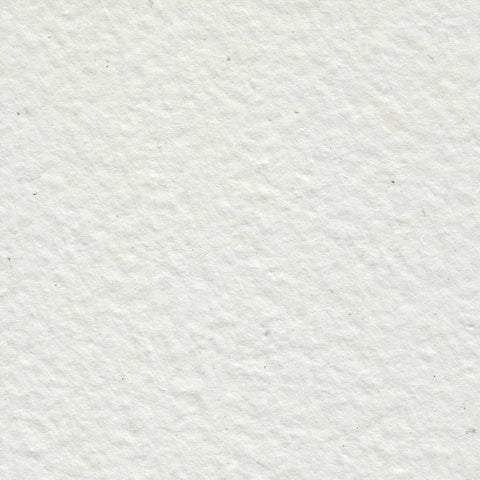 A closeup of light gray deckle edge hand made paper with flecks of ink throughout