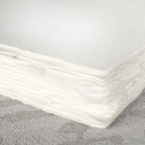 A stack of cotton white deckle edge hand made paper