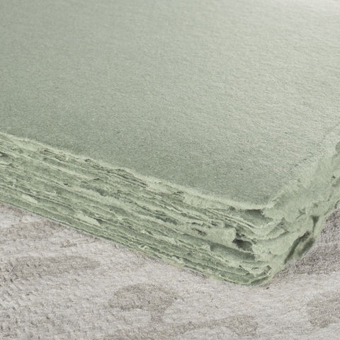 A stack of earthy green deckle edge hand made paper